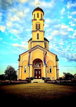 Православни Храм Светог пророка Илије у Карановцу са високим звоником и прелепом фасадом под плавим небом